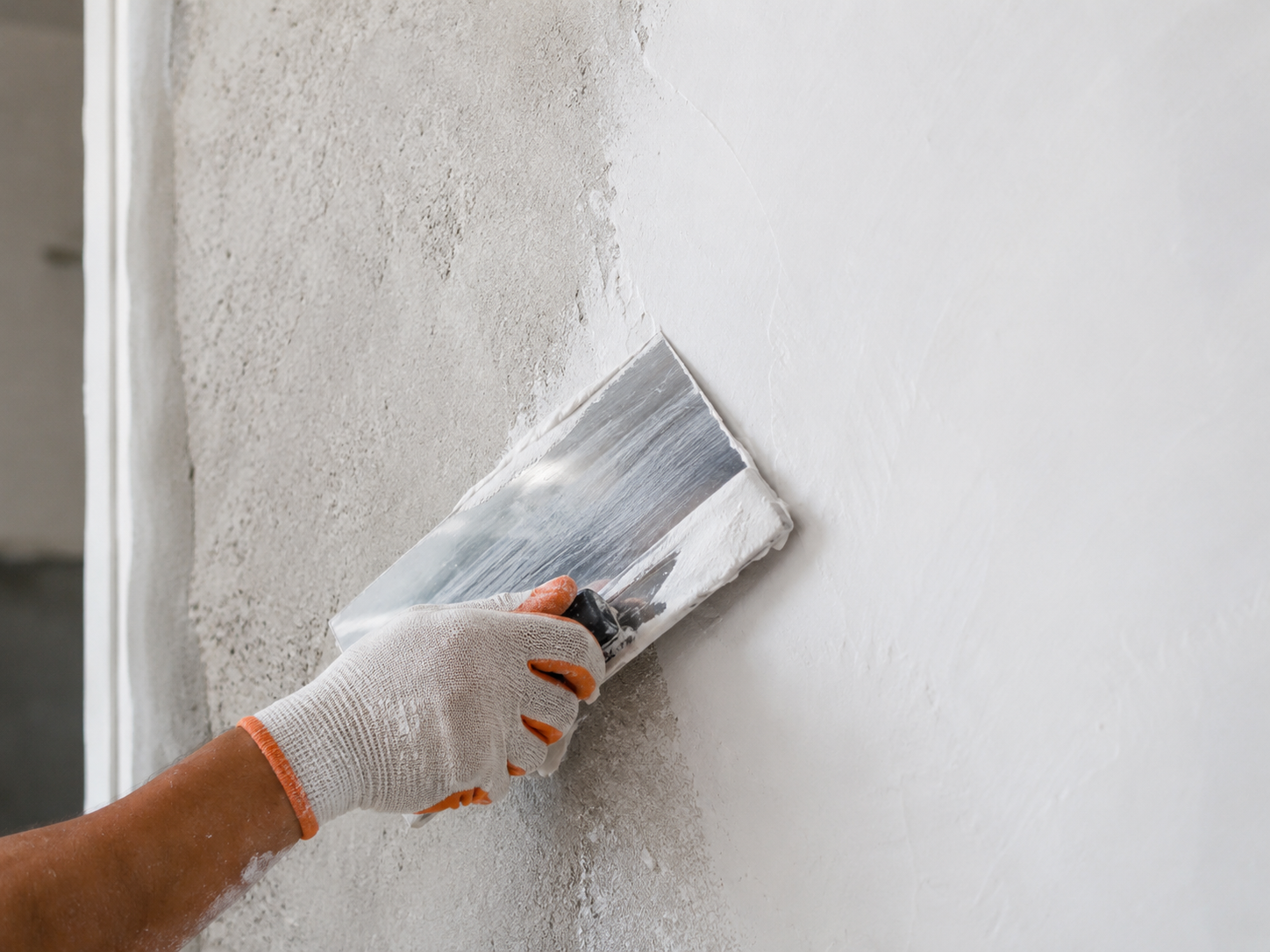 Professional applying smooth wall putty finish